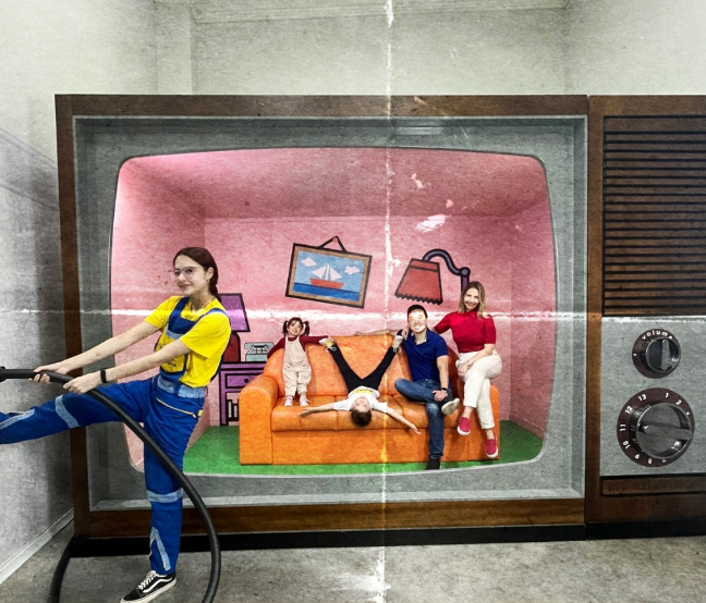 Família dentro da atração Big TV no Big Land, em Canela, posando em um cenário gigante que simula uma televisão antiga, com ambiente lúdico e interativo inspirado nos anos 80 e 90.