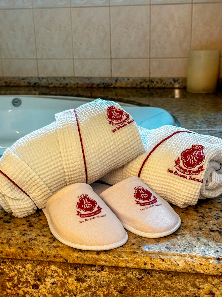 Toalhas e chinelos do Hotel Recanto da Serra, em Gramado, sobre uma bancada de granito, oferecendo conforto e sofisticação para um Carnaval relaxante na Serra Gaúcha.