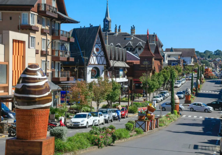 Rua decorada para a Páscoa em Gramado, com grandes esculturas de ovos de chocolate e flores ao longo da avenida, destacando a charmosa arquitetura alpina da cidade, criando um cenário encantador para a celebração da Páscoa.