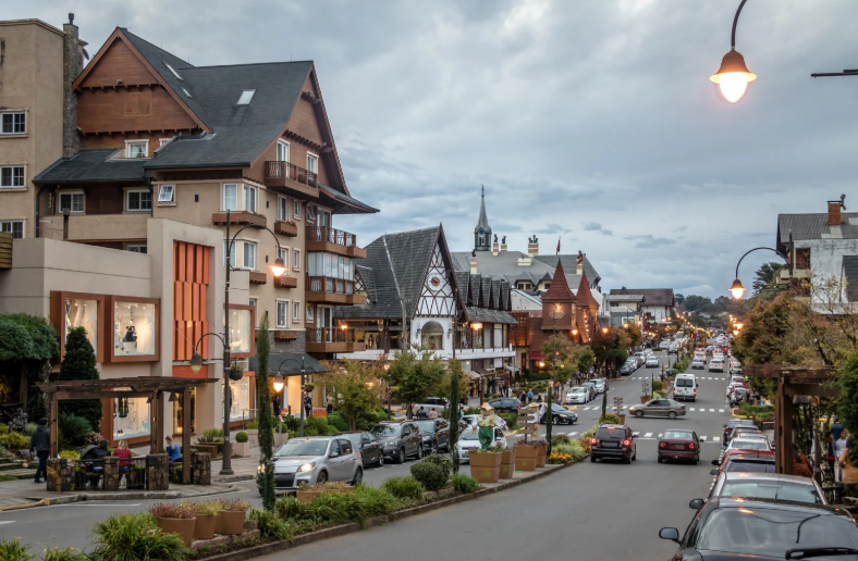 Vista da Avenida Borges de Medeiros, o coração encantador de Gramado, com suas lojas, restaurantes e arquitetura charmosa, atraindo turistas para explorar as melhores opções de compras e gastronomia.
